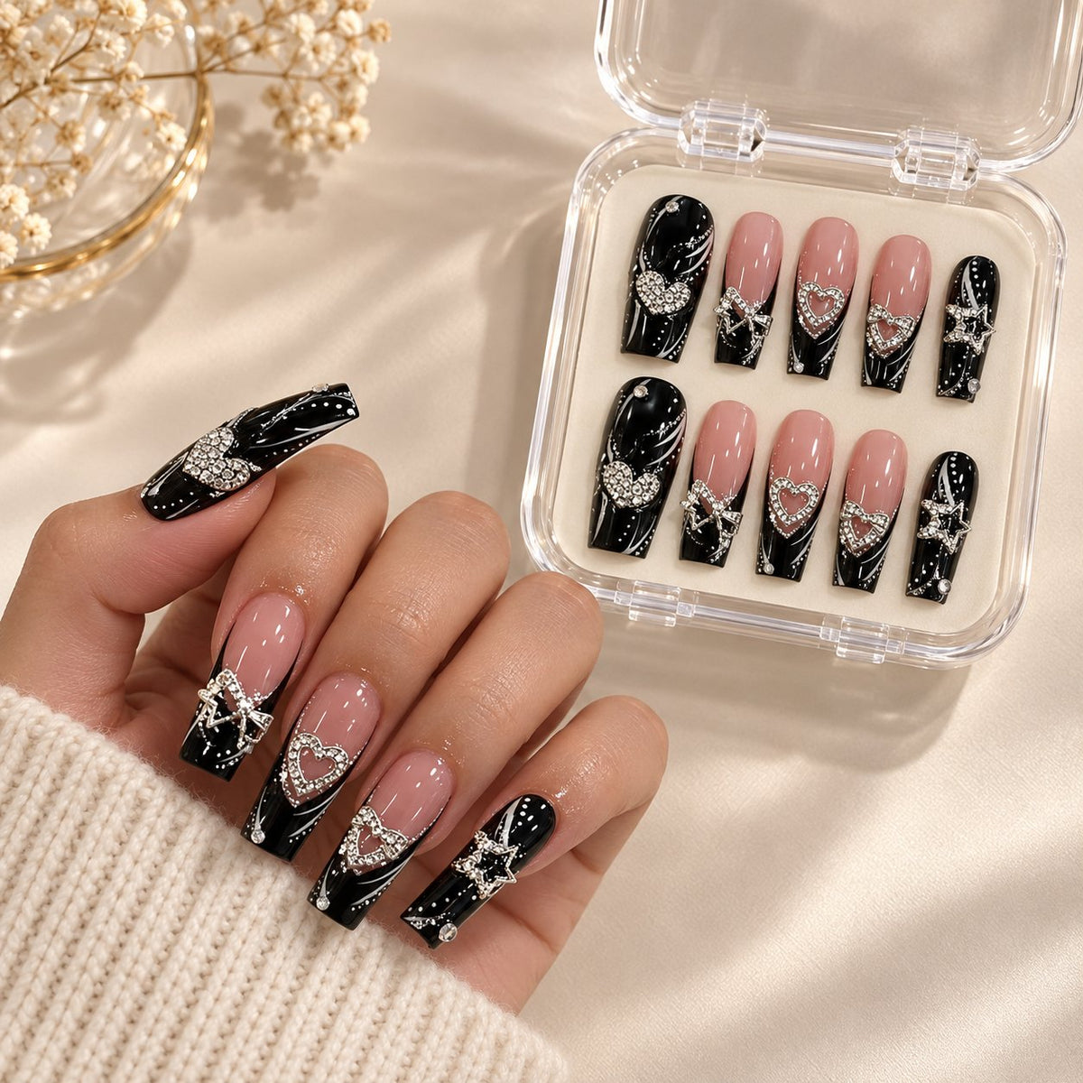 Black and Nude French Tip Press On Nails with Silver Heart Rhinestones worn on hand with acrylic storage box