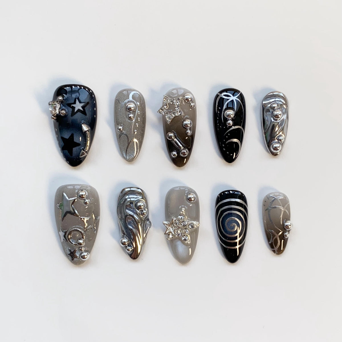 Black and Smoky Gray Star Nails with Silver Chrome Swirls