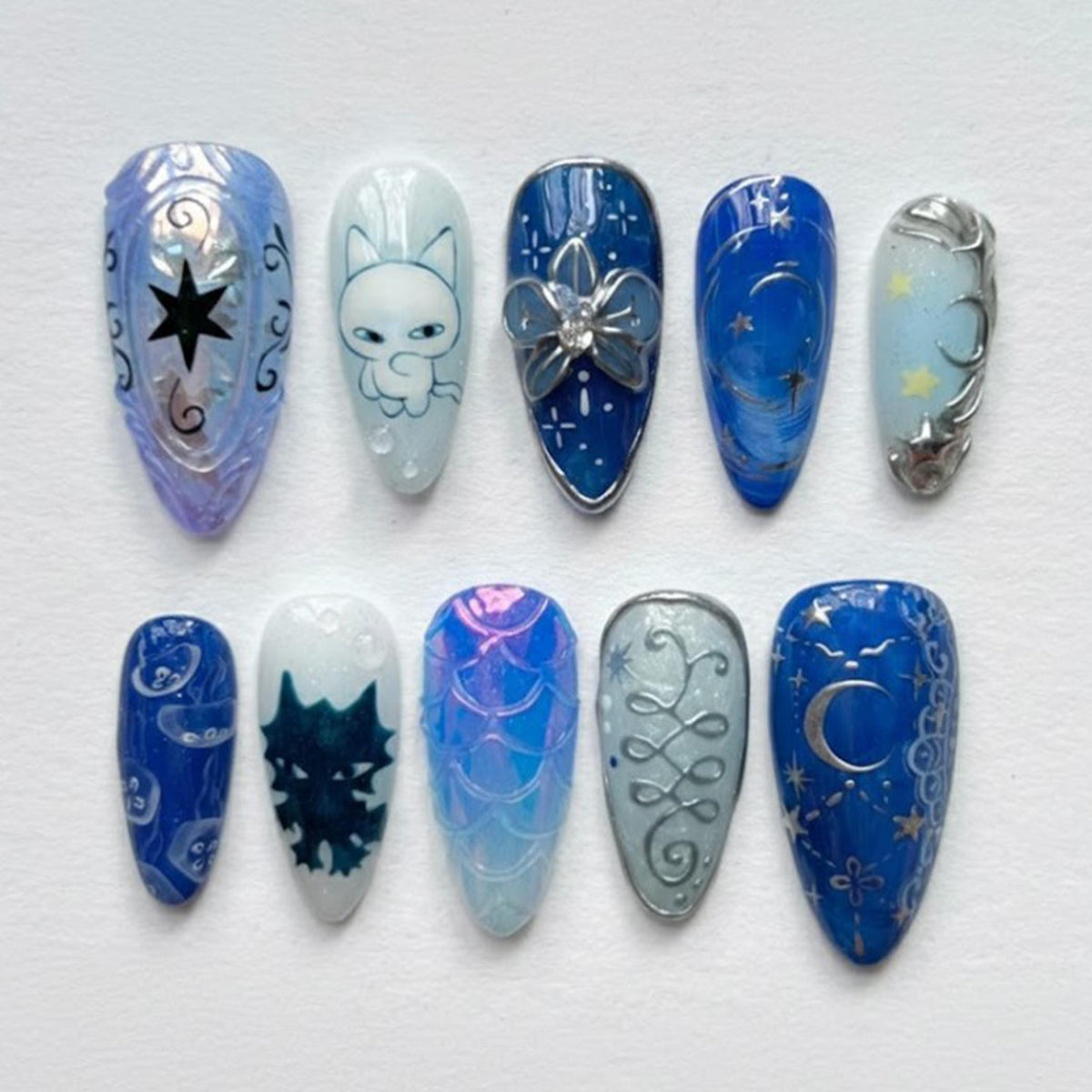 Blue Celestial Press-On Nails with Moons, Stars, Iridescent Scales, and Silver Flower-Like Charm