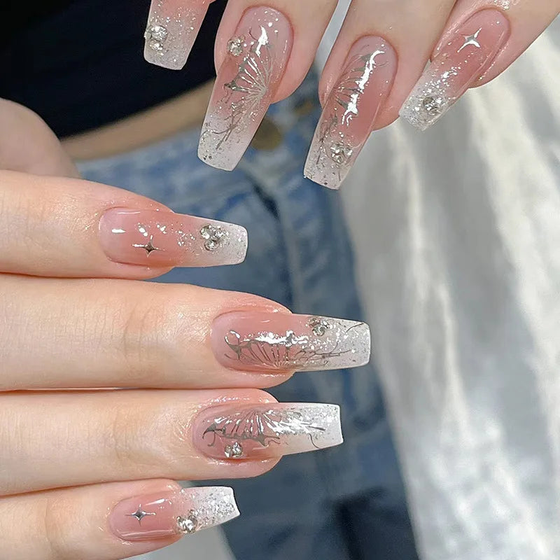 Blush Pink and Silver Glitter Ombre Nails with Butterfly-Wing Details and Rhinestones