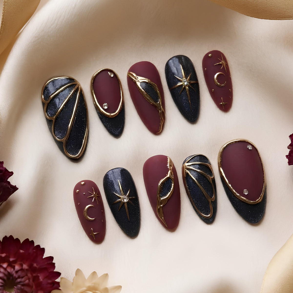 Burgundy and Black Celestial Nails with Gold Stars, Moons, and Rhinestone Accents