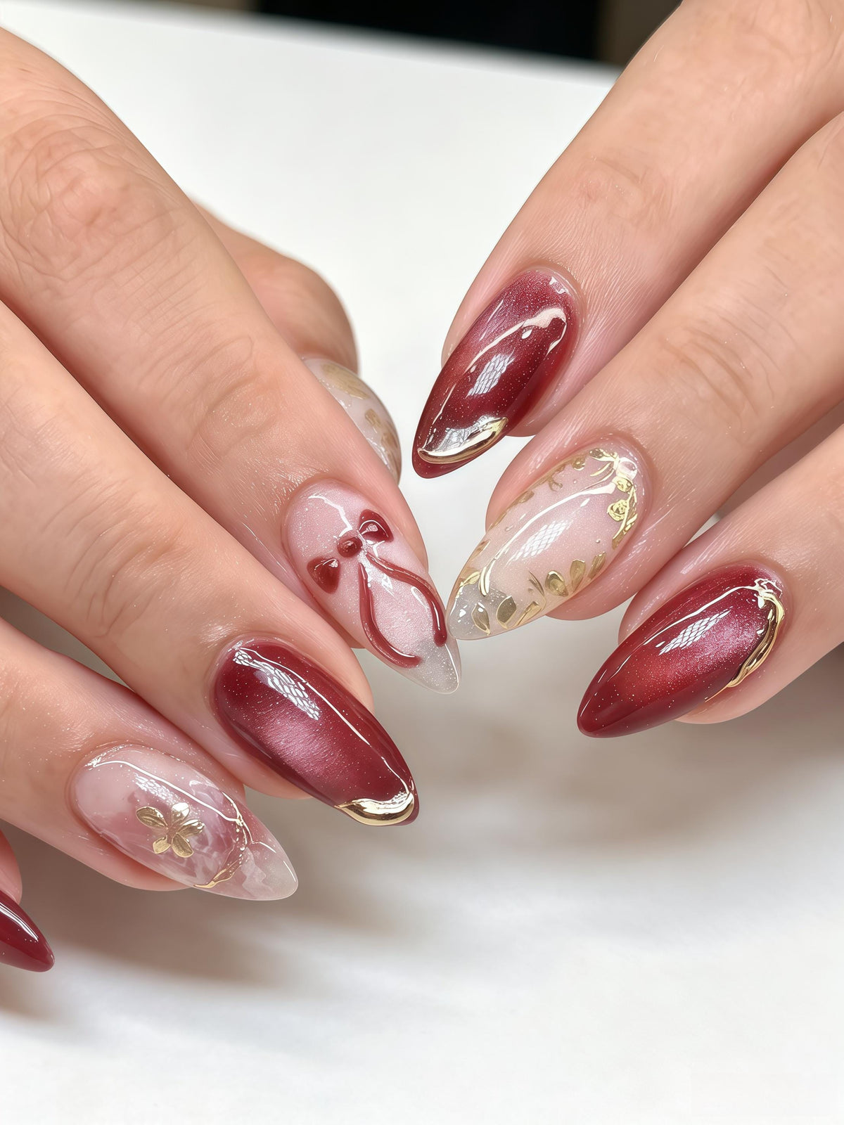 Burgundy Cat Eye Nails With Red Bows, Floral Details & Gold Foil
