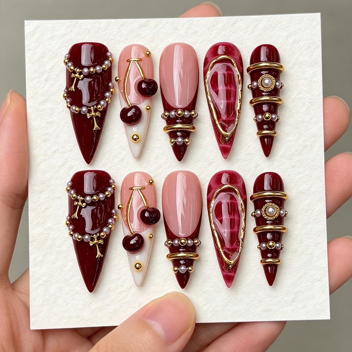 Burgundy Cherry Nails with Pearl Beads and Gold Jewelry Details