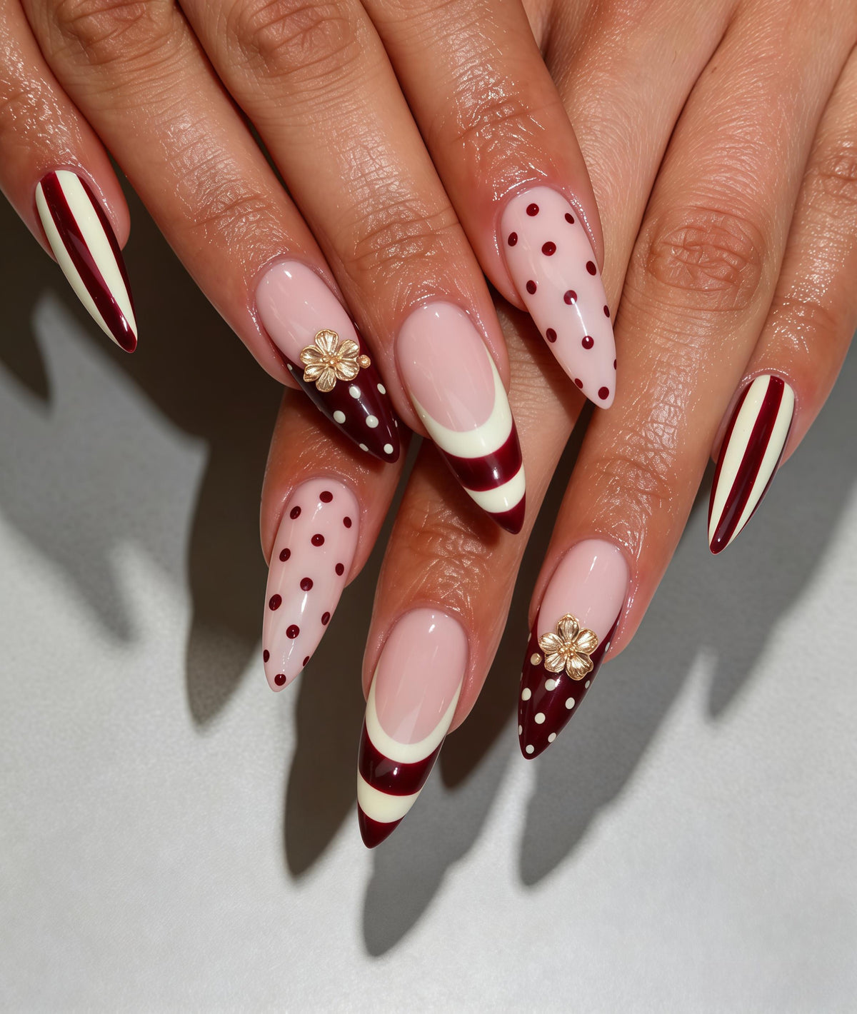 Burgundy Polka Dot and Striped Nails with Raised Gold-Toned Flowers