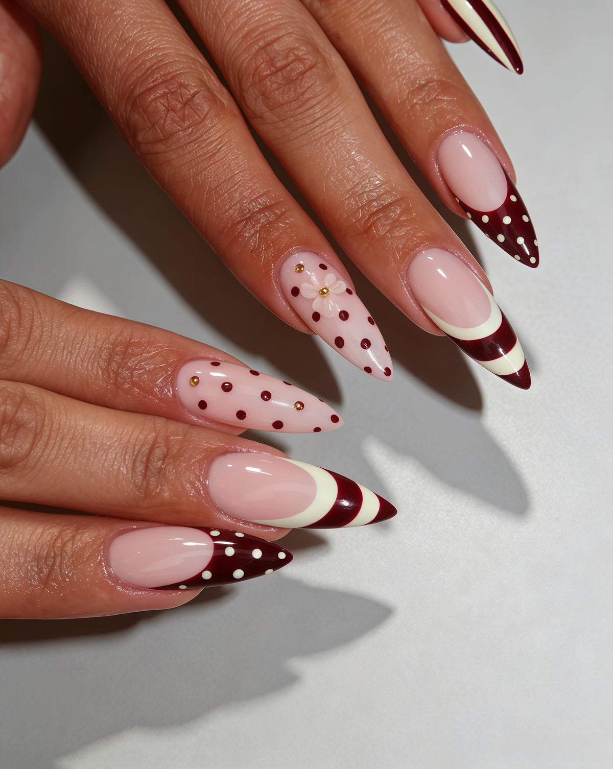 Burgundy Polka Dot and Striped Nails with Raised Gold-Toned Flowers