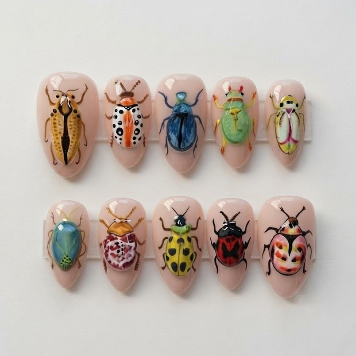 Colorful Beetle and Insect Press-On Nails on a Sheer Nude-Pink Base