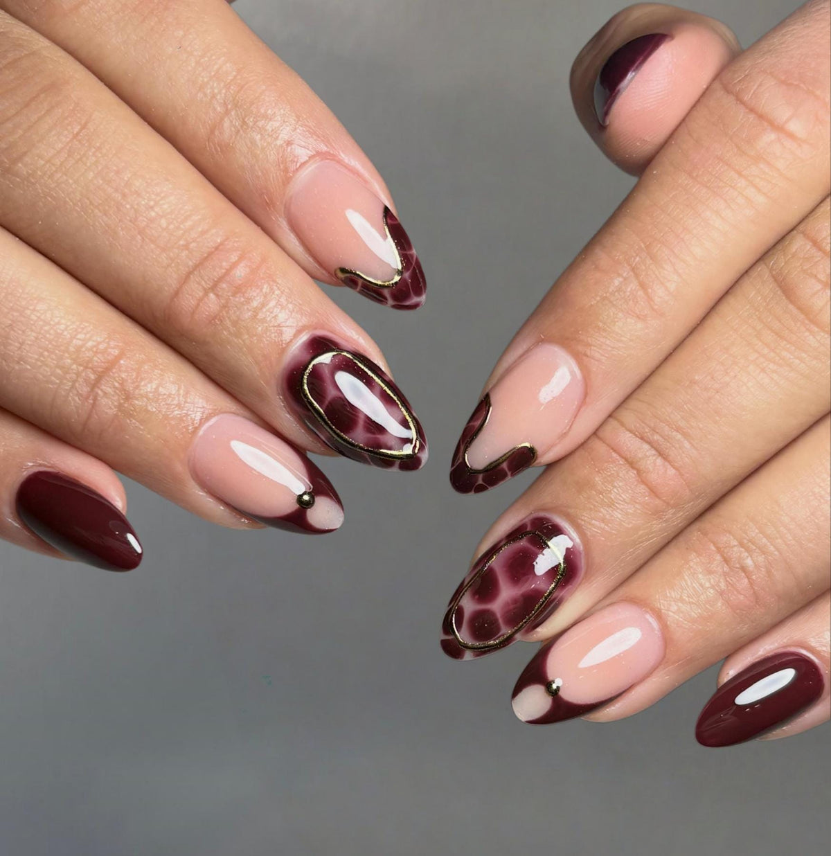 Deep Burgundy French Tip Nails with Leopard Print and Gold-Toned Accents