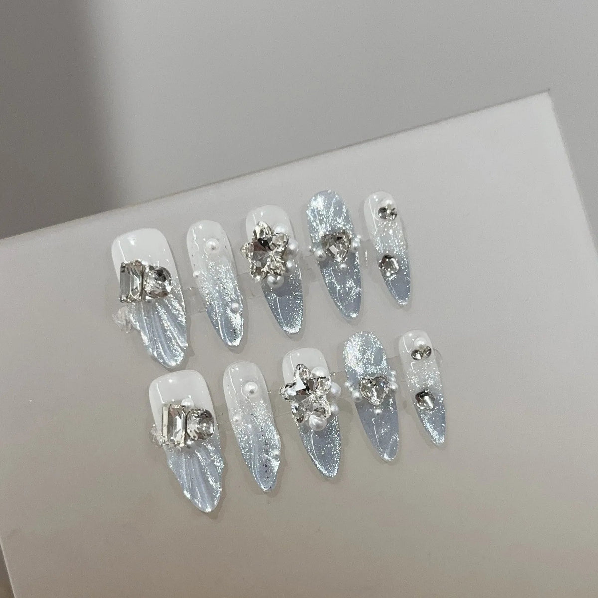 Icy Blue and White Rhinestone Nails with Glitter and Pearl Accents