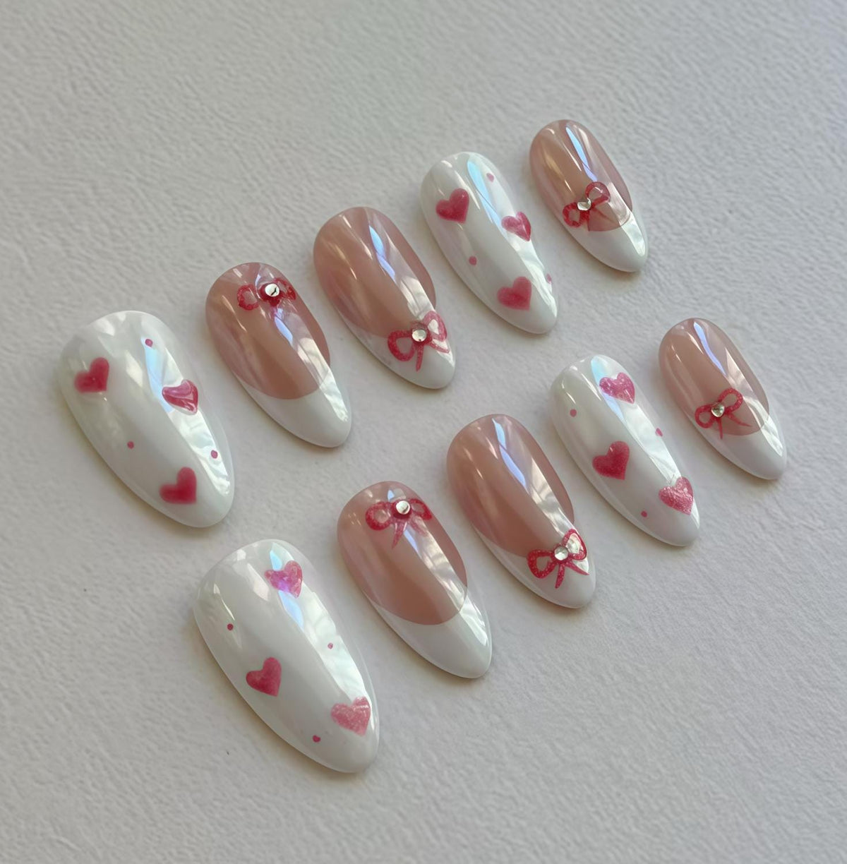 Iridescent French Tip Nails with Red Bows, Hearts, and Rhinestones
