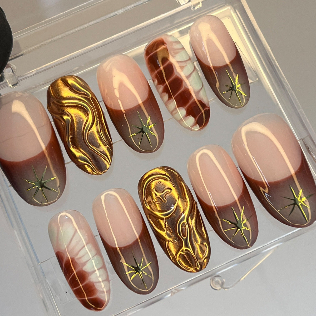 Nude Pink and Brown French Tip Nails with Gold Starbursts and Marble Details