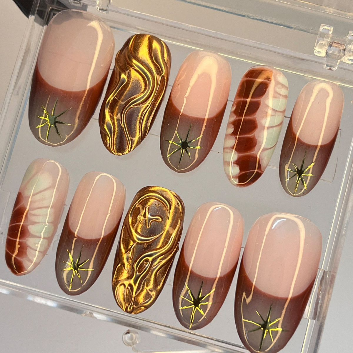 Nude Pink and Brown French Tip Nails with Gold Starbursts and Marble Details