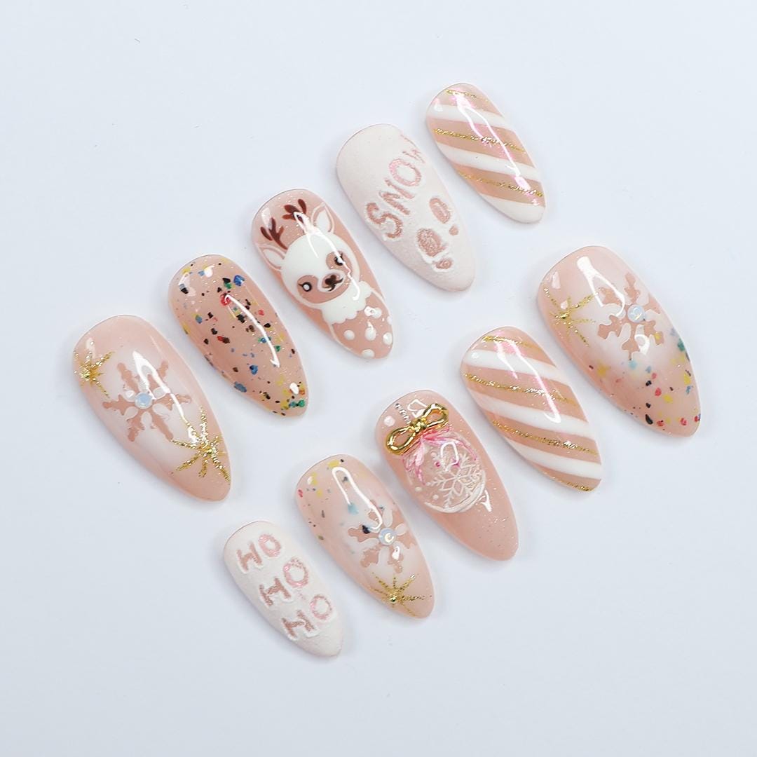 Nude Pink Christmas Nails With Reindeer, Snowflakes, Gold Glitter and Bow Charm