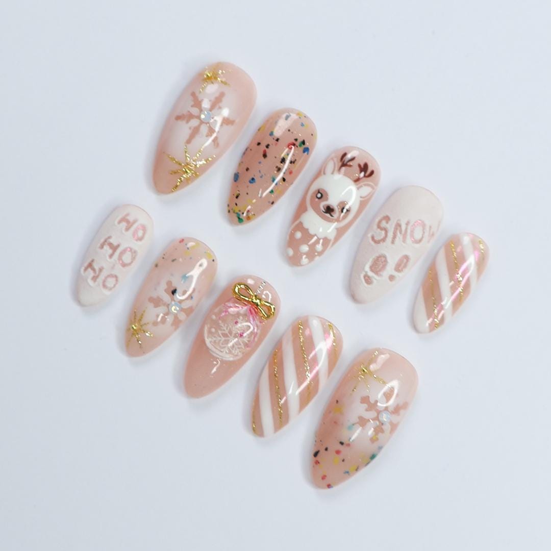 Nude Pink Christmas Nails With Reindeer, Snowflakes, Gold Glitter and Bow Charm