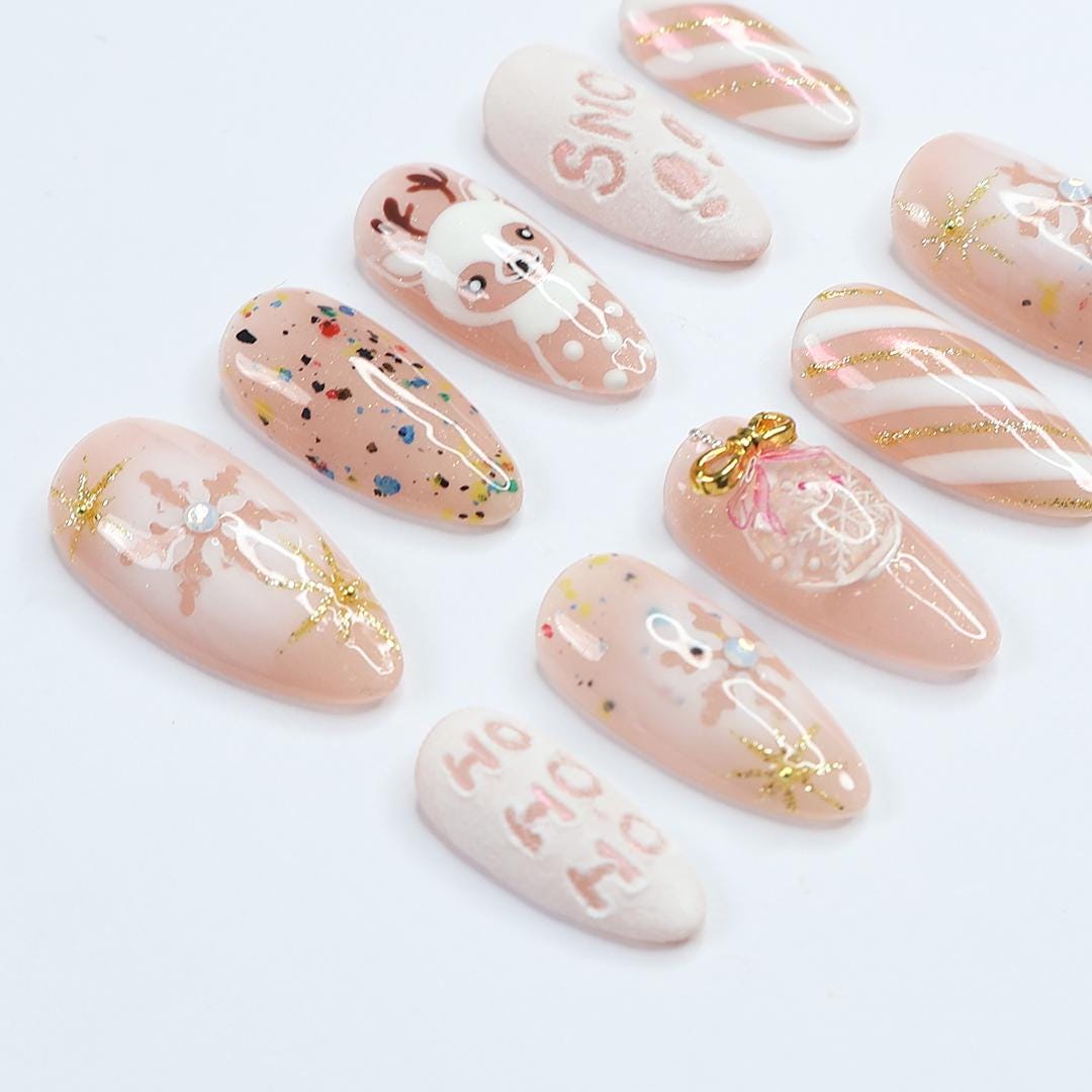 Nude Pink Christmas Nails With Reindeer, Snowflakes, Gold Glitter and Bow Charm