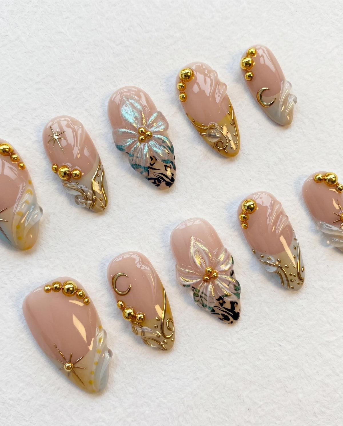 Nude Pink Shell-Inspired Nails with Blue Floral Art and Gold Details