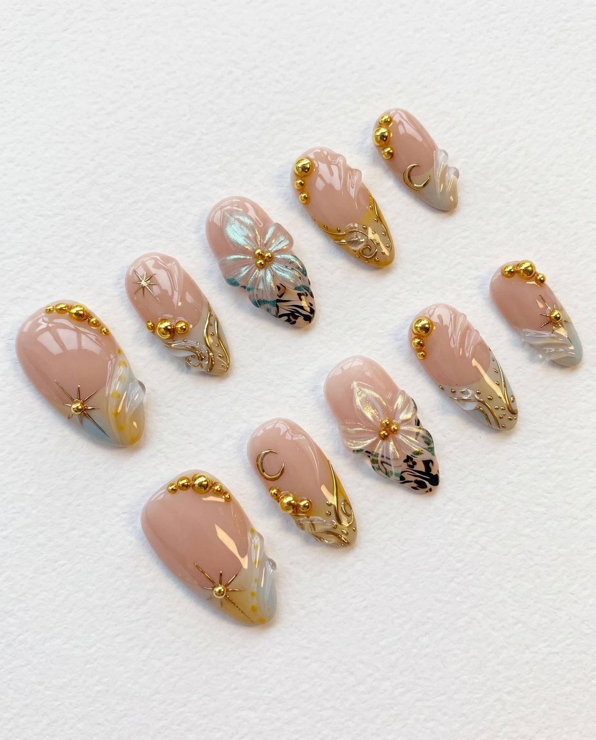 Nude Pink Shell-Inspired Nails with Blue Floral Art and Gold Details