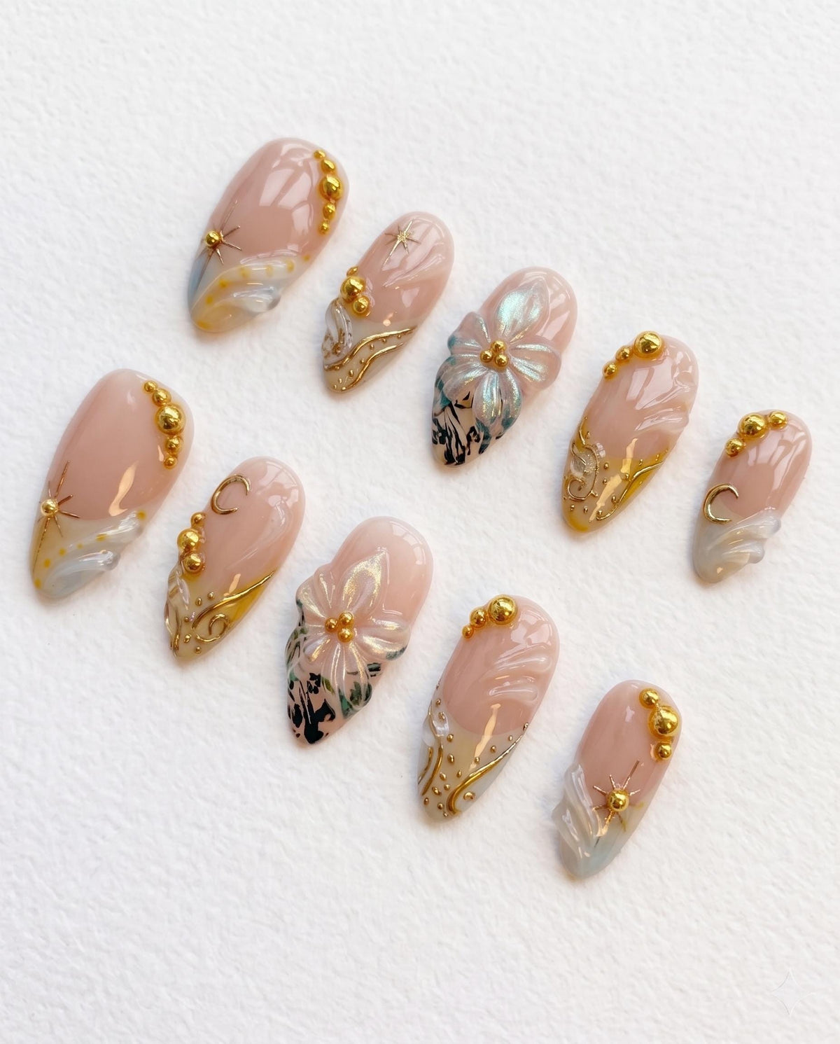 Nude Pink Shell-Inspired Nails with Blue Floral Art and Gold Details
