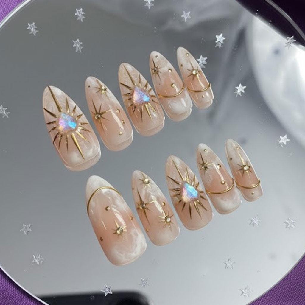 Opal Galaxy Nude Marble Press-On Nails With Gold Starbursts and Iridescent Gems