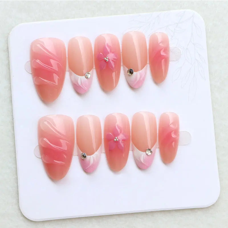 Peach Ripple French Tip Nails With Pink Flowers and Rhinestones
