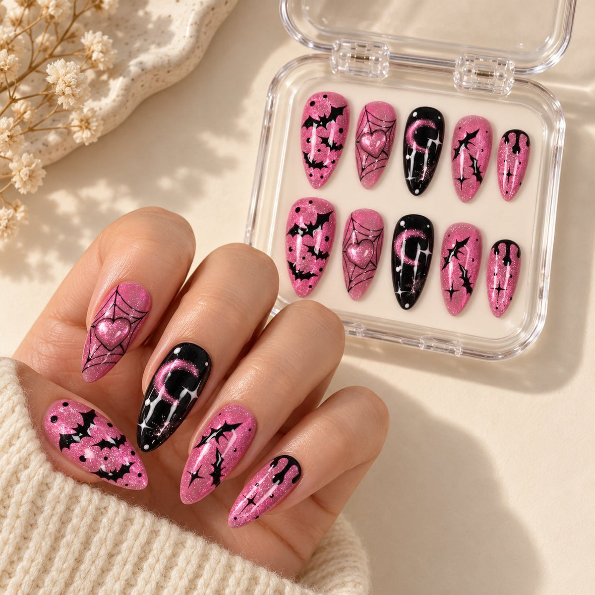 Pink and Black Halloween Bat Nails With Heart, Moon, and Spider Web Art worn on hand with acrylic storage box