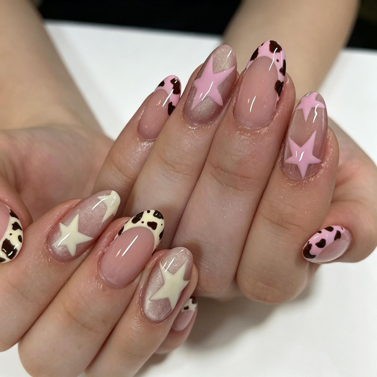 Pink and White Cow Print Nails with Star Accents and Shimmer