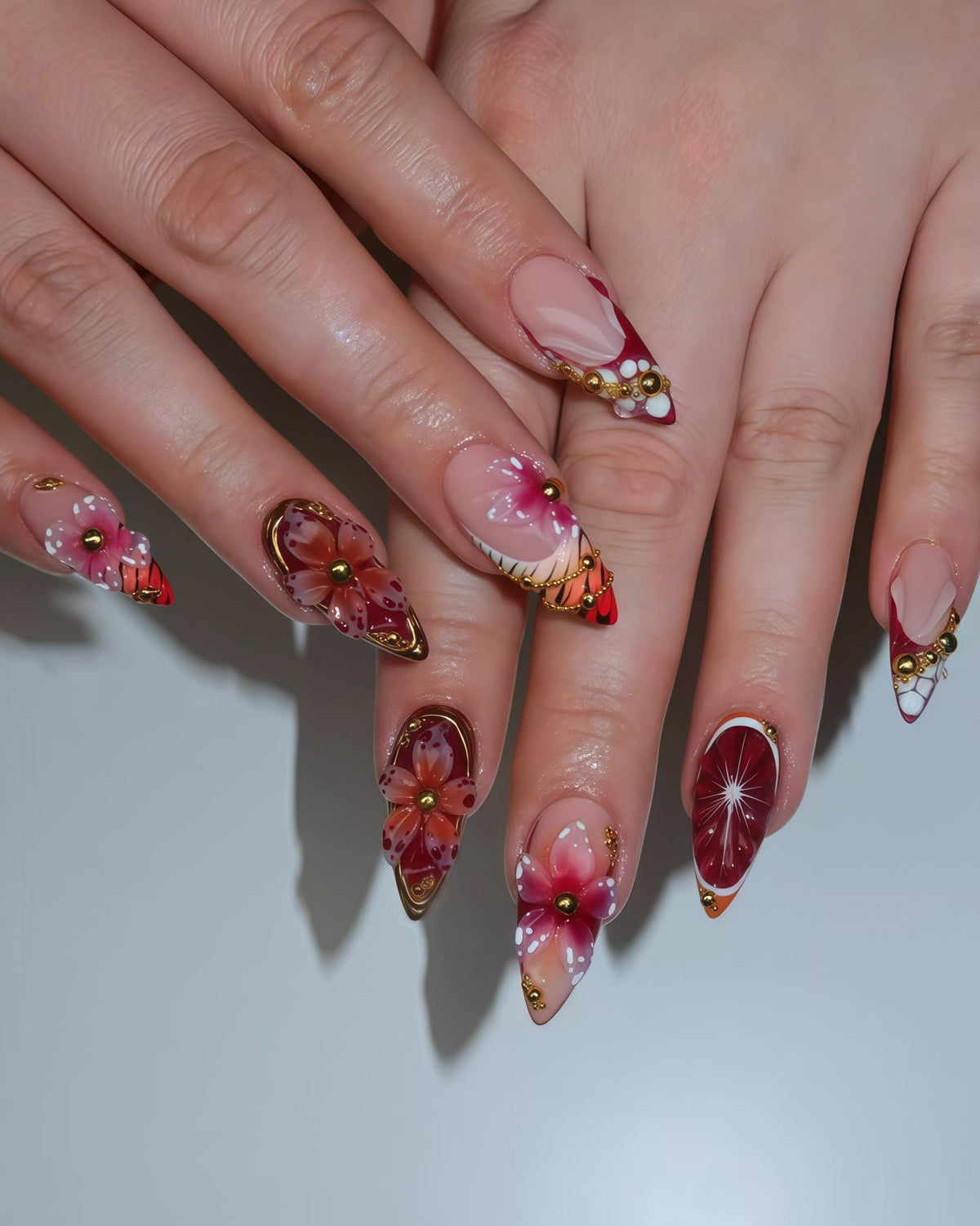 Red and Sheer Pink Floral Butterfly Nails with Gold Beads and Wing-Inspired Stripes