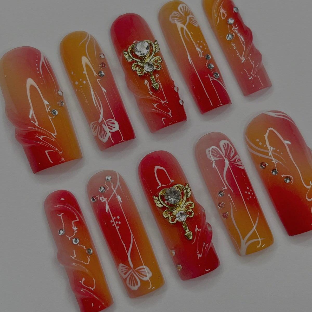 Red, Coral and Orange Gradient Nail Set with White Line Art and Crystal Charms