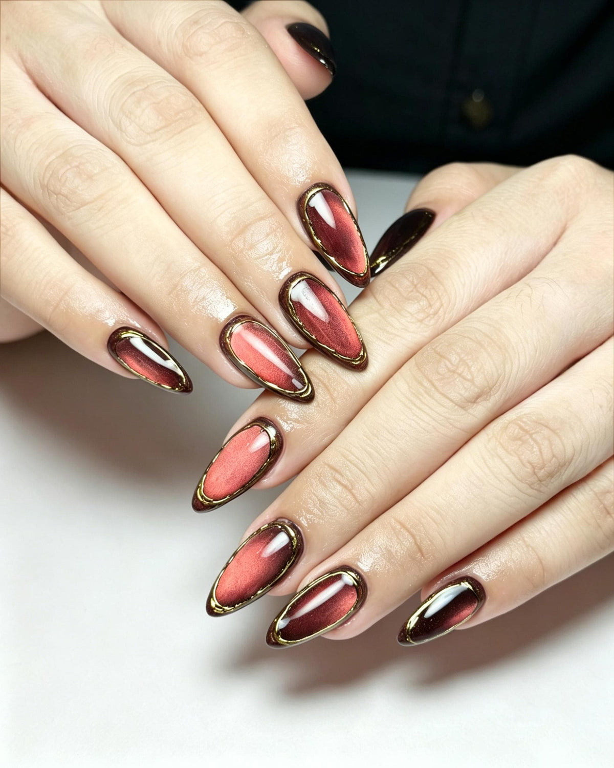 Rosy Red Cat Eye Nails With Burgundy Edges and Gold Trim