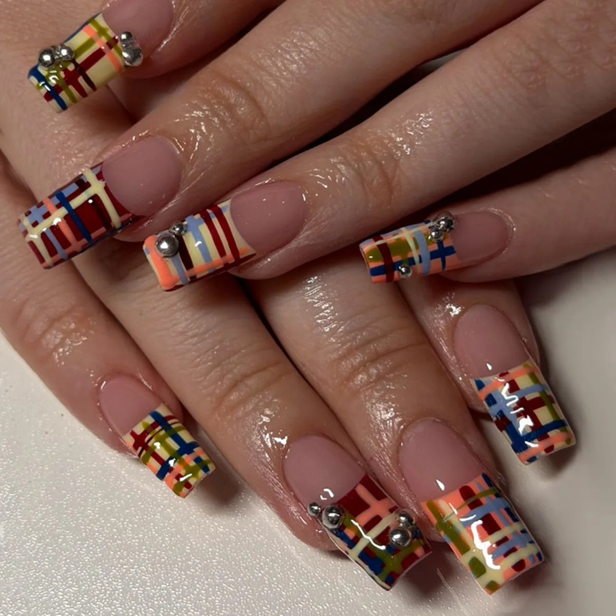 Sheer Nude Pink French Tip Nails With Colorful Stripe Tips and Silver Accents