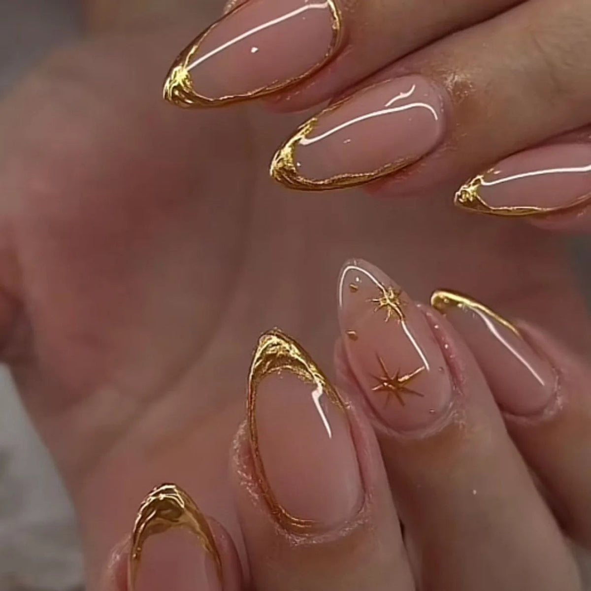Sheer Nude Pink French Tip Nails with Ornate Gold Chrome Borders and Starbursts