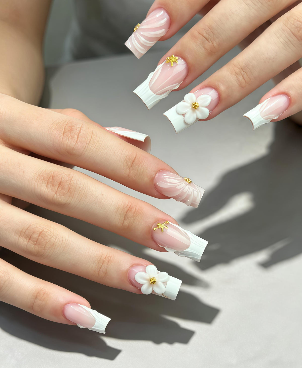 Sheer Pink French Tip Wedding Nails with White Sculpted Flowers and Gold Accents