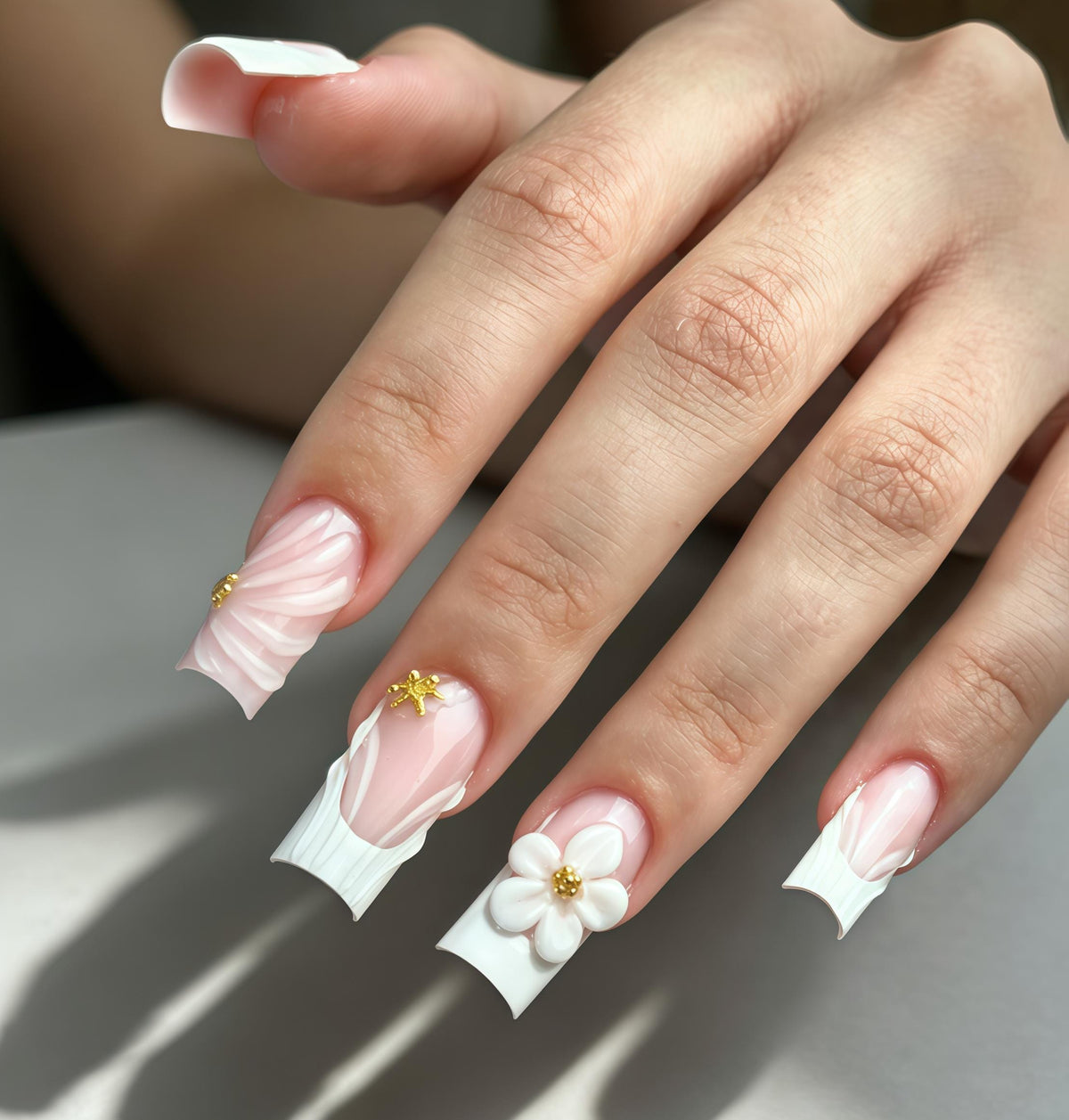 Sheer Pink French Tip Wedding Nails with White Sculpted Flowers and Gold Accents
