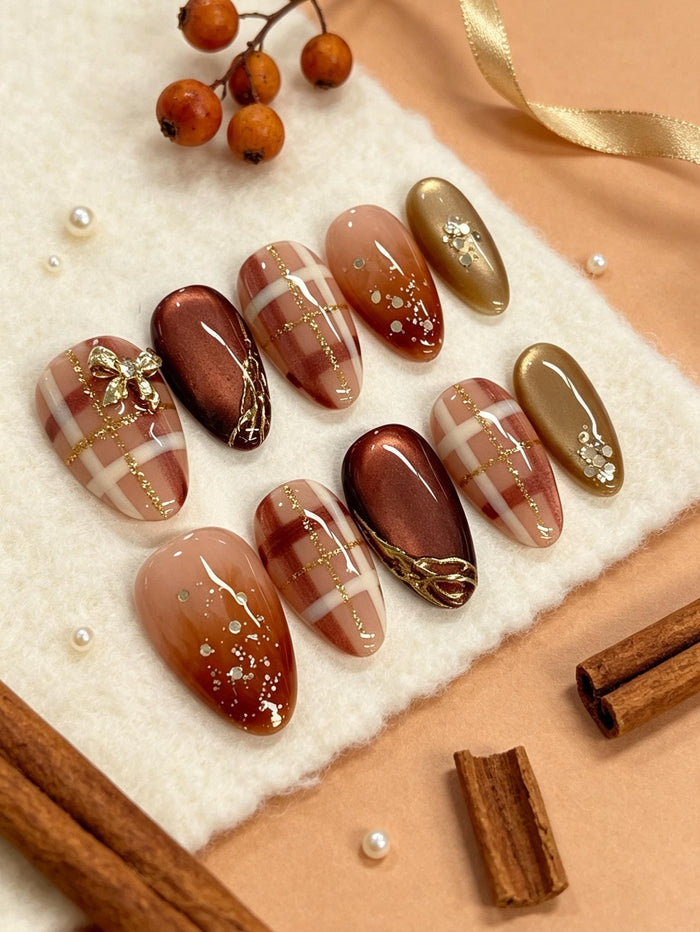 Autumn Plaid Press On Nails With Amber Gradients, Gold Glitter Lines, and Bow Details