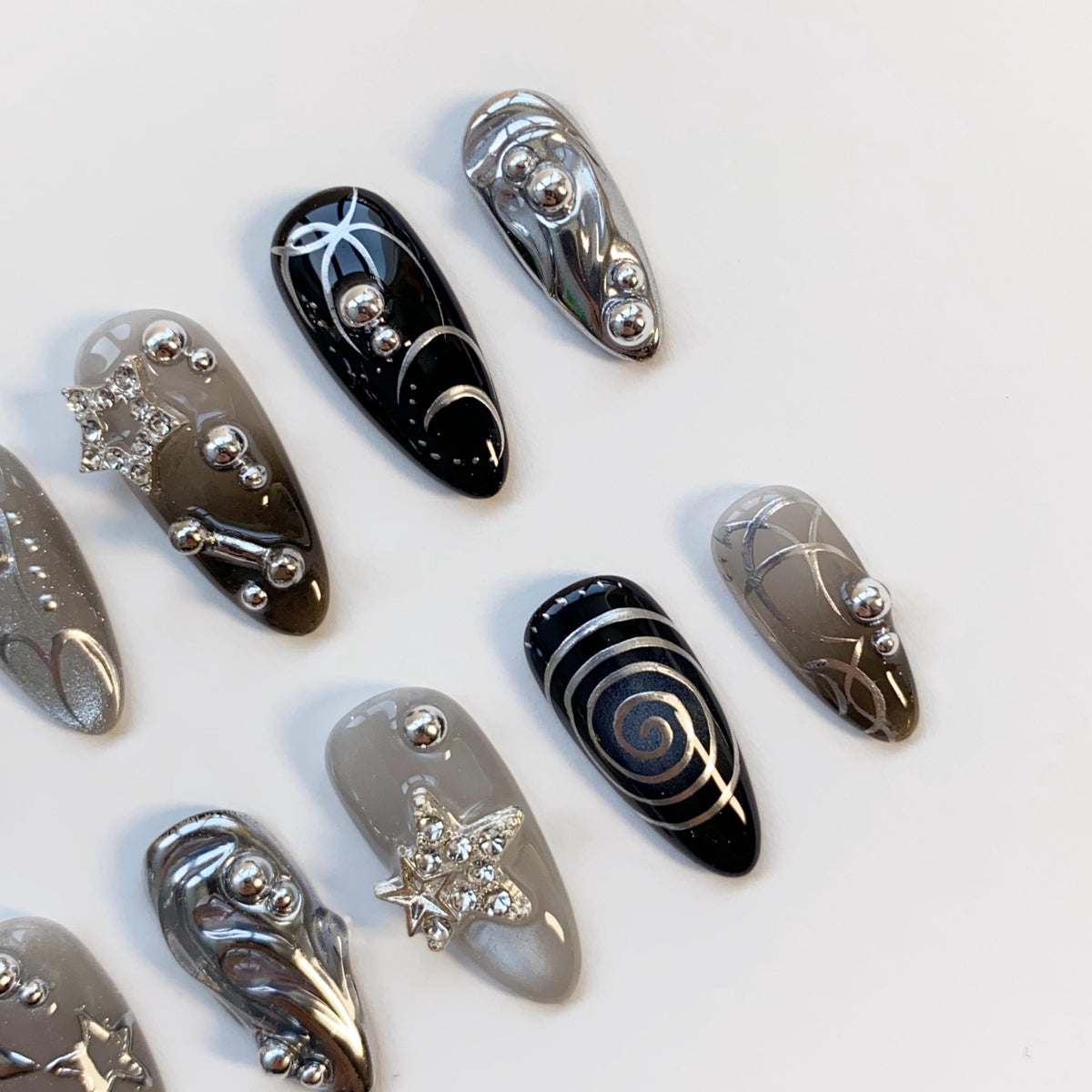 Black and Smoky Gray Star Nails with Silver Chrome Swirls