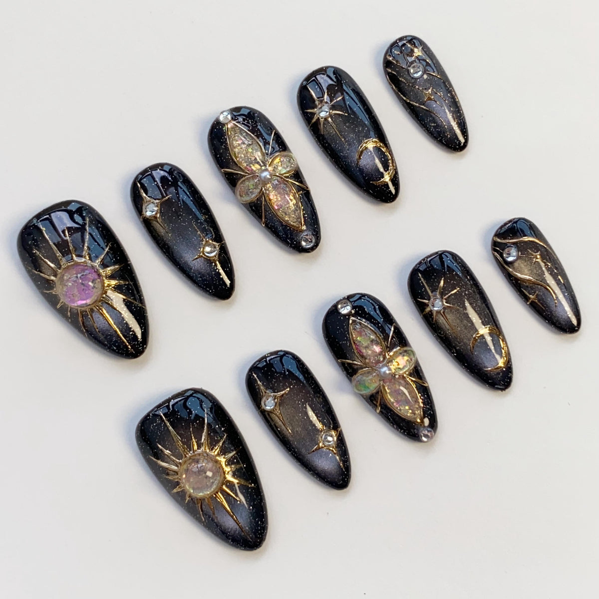 Black Cat Eye Nails With Gold Celestial Details and Gemstone Charms