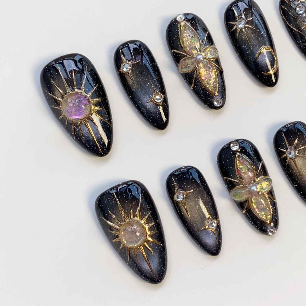 Black Cat Eye Nails With Gold Celestial Details and Gemstone Charms