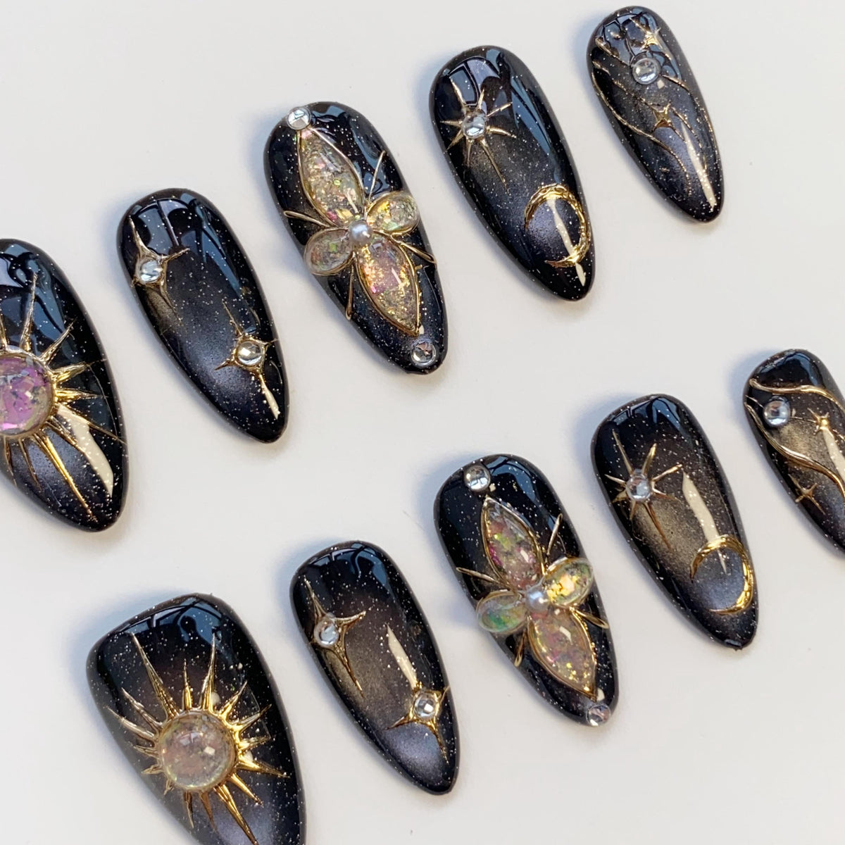 Black Cat Eye Nails With Gold Celestial Details and Gemstone Charms