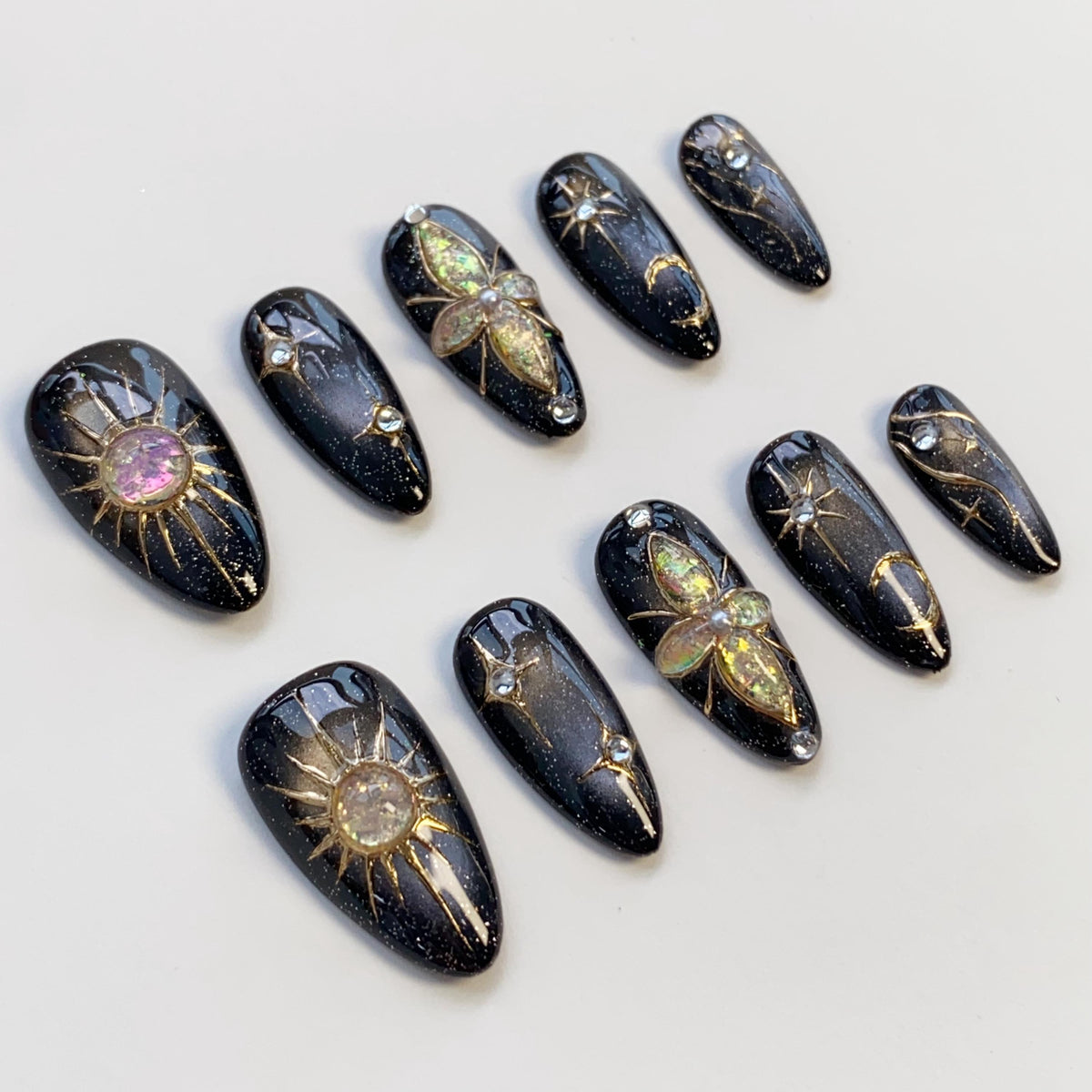Black Cat Eye Nails With Gold Celestial Details and Gemstone Charms