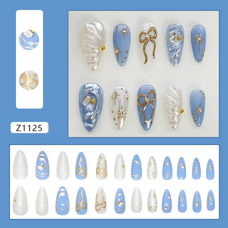 Blue and White Pearl Effect Nails with Gold Bows and Starbursts
