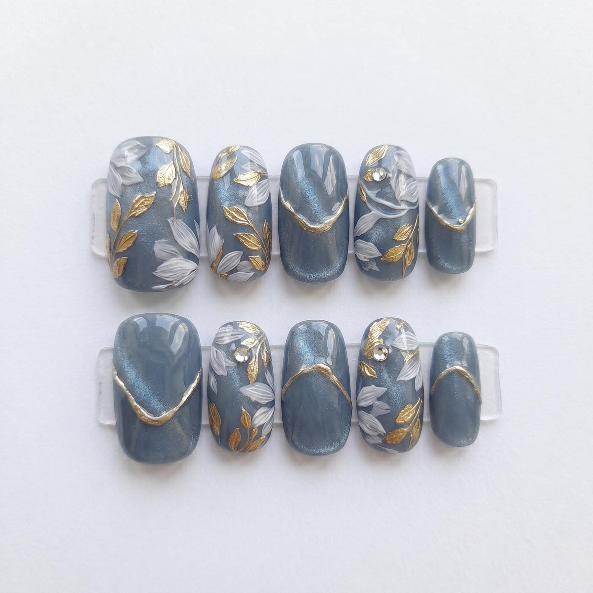 Blue-Gray Cat Eye Nails With Gold Leaf and Botanical Details