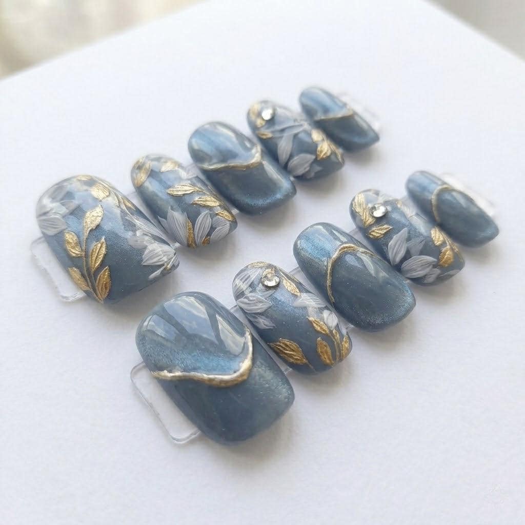 Blue-Gray Cat Eye Nails With Gold Leaf and Botanical Details