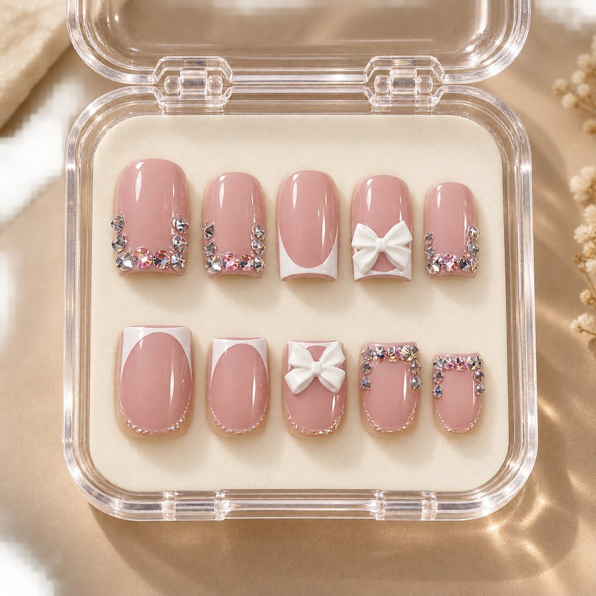 Blush Pink French Tip Nails With 3D White Bows and Rhinestones in clear acrylic storage box