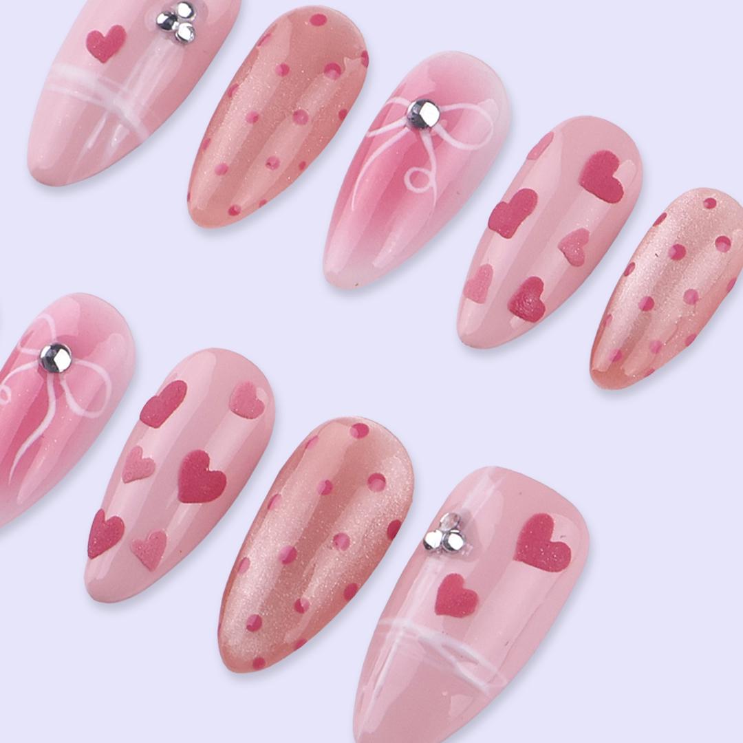 Blush Pink Valentine Nails with Hearts, Polka Dots, and Rhinestone Bows