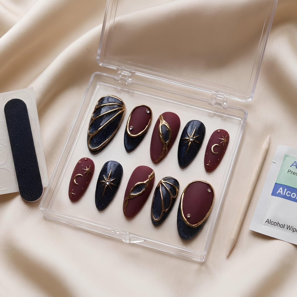 Burgundy and Black Celestial Nails with Gold Stars, Moons, and Rhinestone Accents