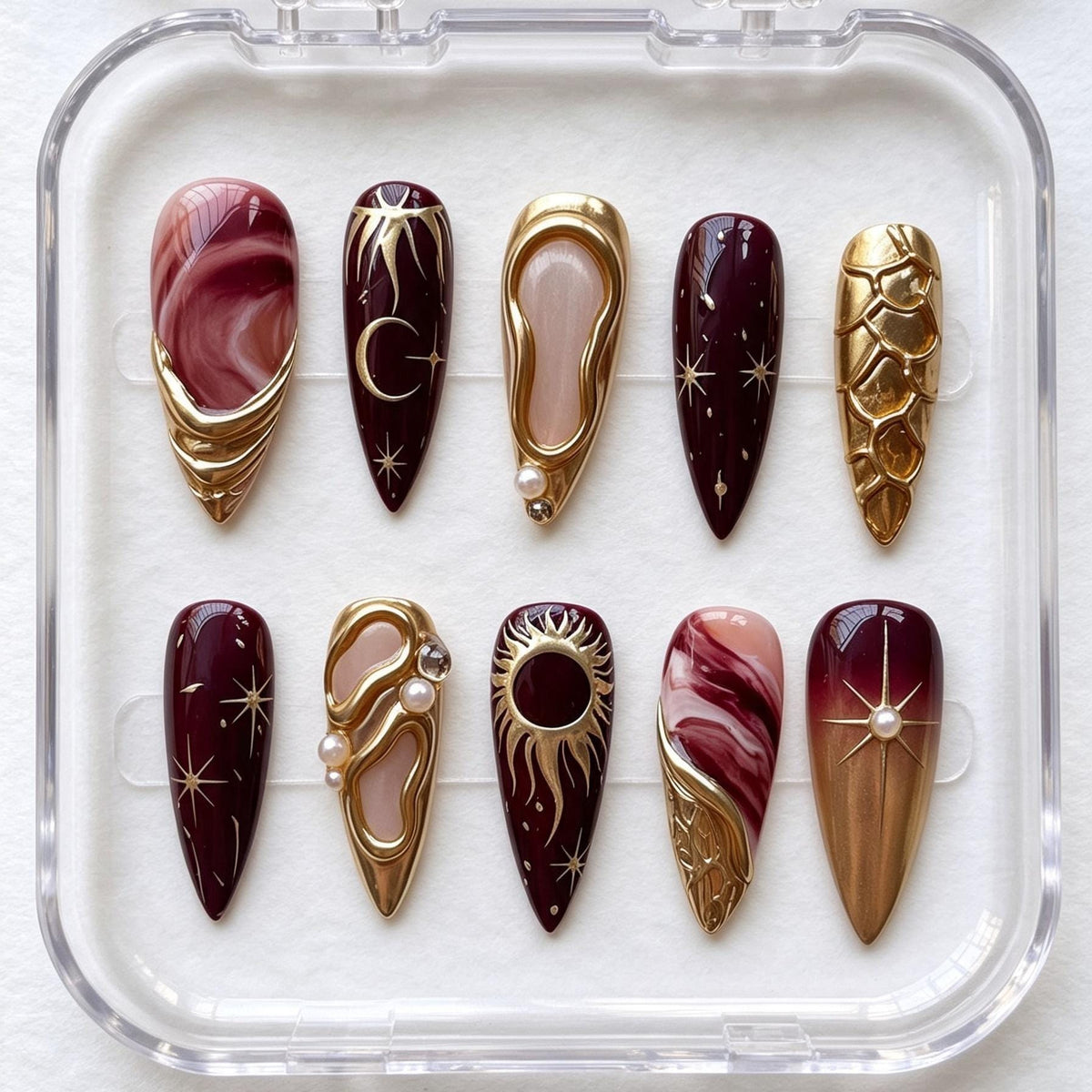 Burgundy and Rose Marble Celestial Nails with Gold Sun, Moon, and Pearl Details
