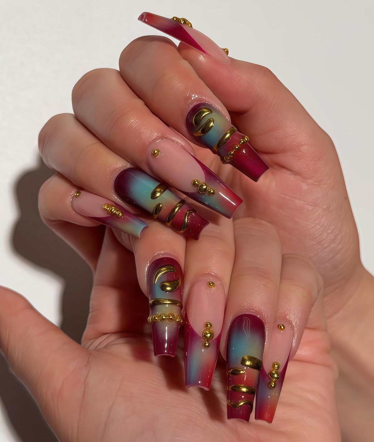 Burgundy and Teal Gradient Nails with Gold-Toned 3D Details
