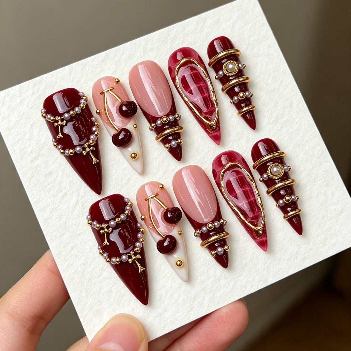 Burgundy Cherry Nails with Pearl Beads and Gold Jewelry Details
