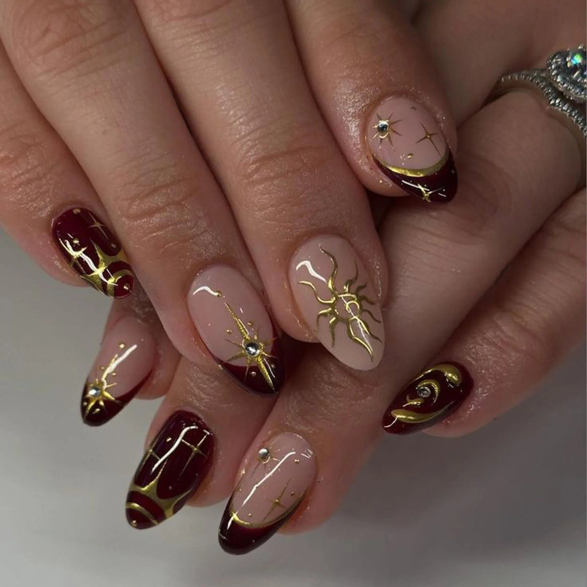 Burgundy French Tip Nails with Gold Celestial Designs