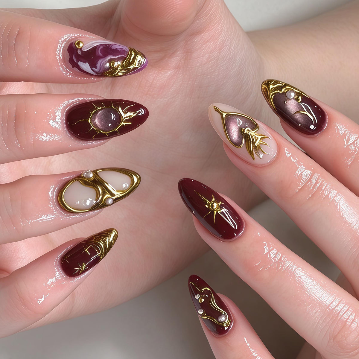 Burgundy Marble Nails with Gold Celestial Scrollwork and Pearl Details