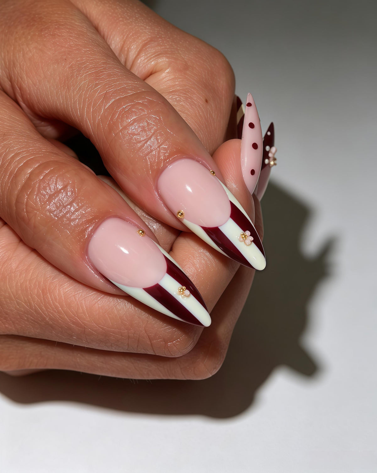 Burgundy Polka Dot and Striped Nails with Raised Gold-Toned Flowers